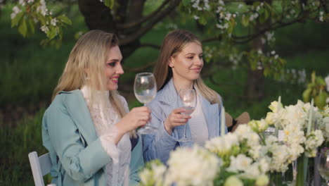 hen-party-in-garden-in-spring-day-happy-women-are-clinking-glasses-with-wine-and-cocktails